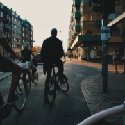 A photo of biker standing in a traffic light waiting to rde forward | Cycling in Copenhagen | The Best Ways to Be Sustainable in Denmark | Amitylux Tours | Scandinavian Guided Tours | VIP & Luxury Experiences in the Nordics