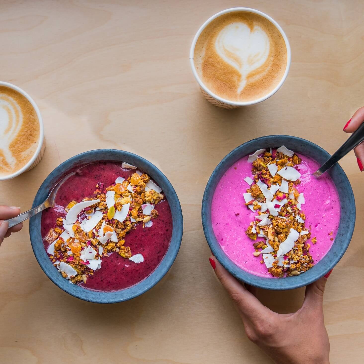 A photo of two bowls of cereals and two full coffee cups at Palæo Illum | The Best Breakfast Places in Copenhagen | Amitylux Tours | Scandinavian Guided Tours | VIP & Luxury Experiences in the Nordics