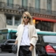 A photo of a blonde woman posing outside in the street | Scandinavian Fashion: The Amazing And Unique Style | Amitylux Tours | Guided City Tours | VIP & Luxury Experiences