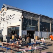 An outside photo of Mikkeller showing people sitting outside on benches drinking beer | The Best Beer Bars in Copenhagen: Our Top 4 Favorite | Amitylux Tours | Guided City Tours | VIP & Luxury Experiences