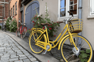 A yellow bike parked across a house