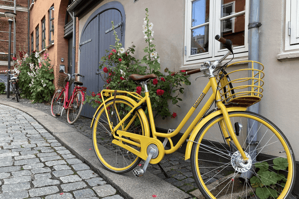 A yellow bike parked across a house