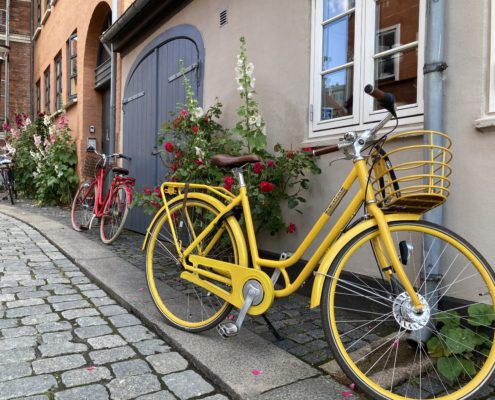 A yellow bike parked across a house | Danes and Bikes | Danes and Bikes: A Powerful and Unique Relationship | Amitylux Tours | Guided City Tours | VIP & Luxury Experiences