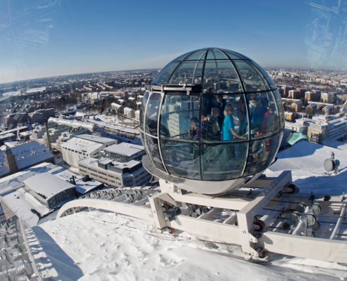 An outside photo of Avicii Arena at the top showing people inside the round teleporting sphere in the snowy top of tue building | Stockholm (Part 2): A Must See List of Unique Sites | Amitylux Tours | Scandinavian Guided Tours | VIP & Luxury Experiences in the Nordics