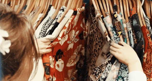 female thrift shopping colorful shirts
