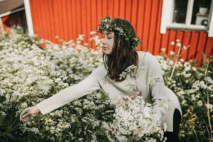 a girl with a flower crown picking flowers