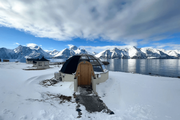 glass igloo hotel with mountains and a lake
