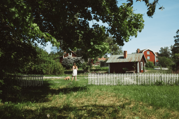 a countryside house with a yard and a girl