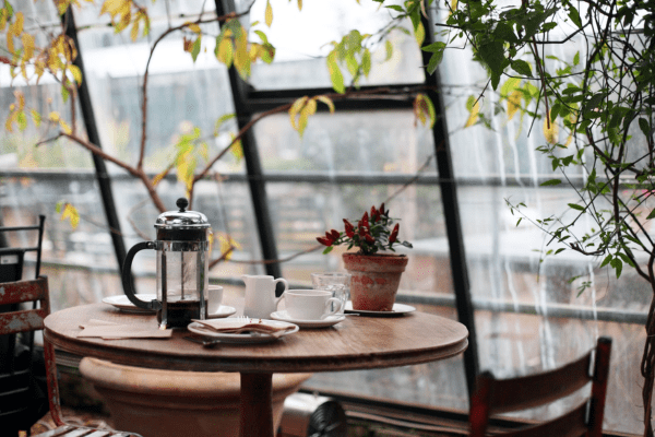 a cafe with wooden furniture and plants